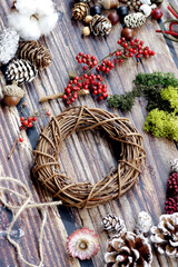 The materials for making Christmas wreaths on the table include cane rings, pine cones and ribbons. Christmas decoration.