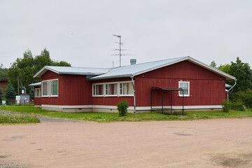Obraz premium Charming Red Wooden House Located in a Beautiful, Serene Landscape, Surrounded by Nature