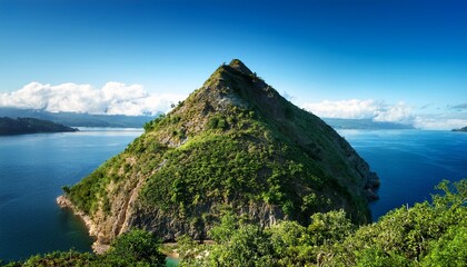 a view of a triangular mountain covered in greenery near a body of water