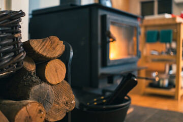 Stacked Firewood Next to a Lit Wood-Burning Stove