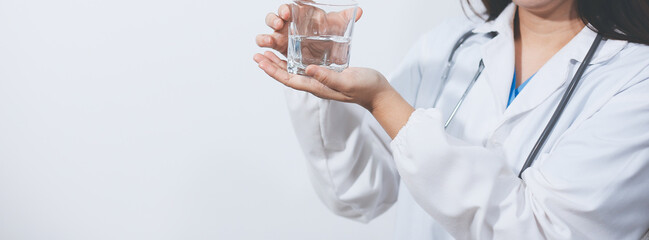 Portrait of Asian doctor woman standing holding coffee cup in white studio background