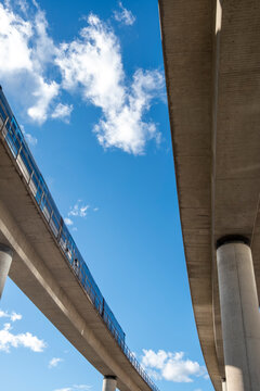 Upward angle of metro viaduct structure in Kista Stockholm, blue sky background highlighting scale, engineering strength and the integration of mobility infrastructure