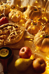 Autumn Harvest Table With Pumpkin Pie, Apples, Pears, And Cozy Fairy Lights