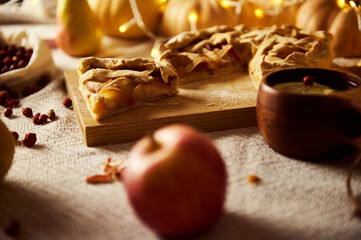 Autumn Thanksgiving Pie Table Scene With Apple Pie, Cranberries, Candles, Pumpkins, and Warm Lighting
