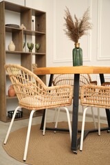 Wooden table with decor and stylish chairs in dining room