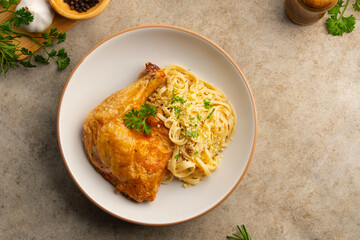 Grilled chicken with carbonara pasta,Air fryer grilled whole chicken leg with fettuccine carbonara sauce in white plate.Top view.