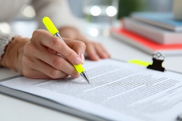 Close-up shot showcasing a hand with a vibrant yellow pen highlighting text on a clipboard. The scene symbolizes focus, learning, and productivity, ideal for business presentations, educational