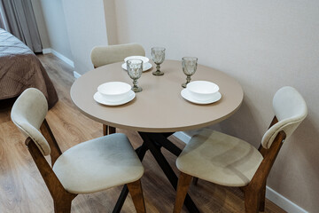 A stylish contemporary dining table with elegant tableware and comfortable chairs enhances the spaces aesthetics, creating a warm and inviting atmosphere that reflects a chic lifestyle
