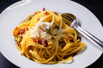 close up of spaghetti carbonara in white bowl