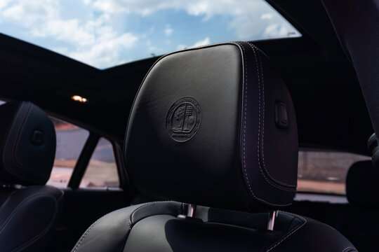 Mercedes-AMG crest embossed on a black leather headrest, Performance SUV interior detail

