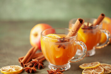 Homemade Wassail Mulled Apple Cider with Lemon and Spices in glasses. Winter alcoholic hot drink.