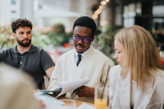 A diverse group of professionals engaged in a discussion, outdoors, emphasizing collaboration and focus.