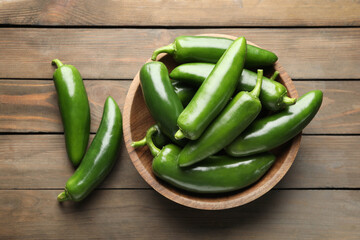 Fresh jalapeno peppers on wooden table, top view