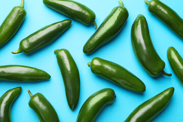 Green jalapeno peppers on light blue background, flat lay