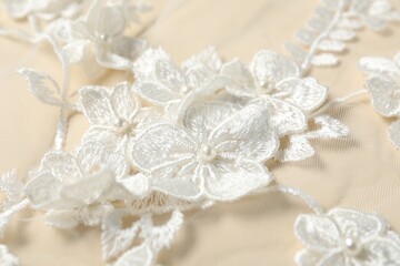 Beautiful lace fabric with floral pattern and pearl beads, closeup