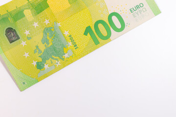 Close-up of a 100 euro banknote on a white background, symbolizing finance, wealth, savings, currency, or economic value.