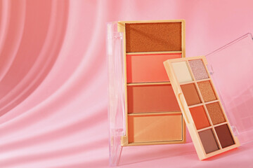 Stylish presentation with colorful eyeshadow palettes on pink background with shadows, closeup. Space for text
