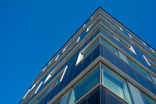Glass fa&ccedil;ade reflecting urban skyline in Stockholm, perspective architecture highlighting transparency, geometry and modern Scandinavian design integrated into contemporary city fabric      
