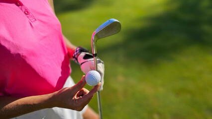 Woman preparing to putt a golf ball on a sunny day at the golf course concept