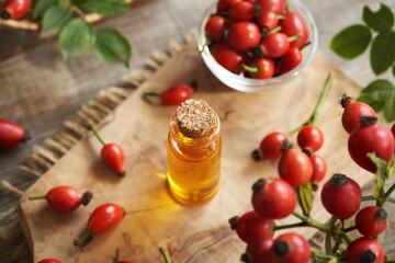 A bottle of rosehip seed oil with fresh rose hips