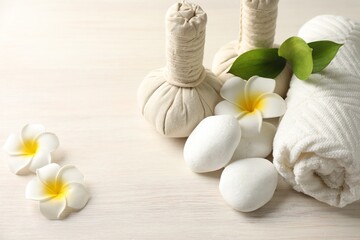 Beautiful spa composition with herbal bags on white wooden table, closeup