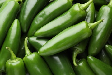 Many green jalapeno peppers as background, closeup