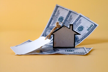 Blank tag sale with miniature houses board on bank note.