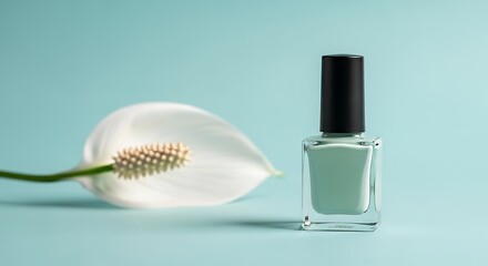Elegant pale green nail polish bottle next to a white calla lily flower