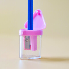 Pink pencil-sharpener on a over color background.