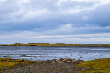 Icelandic coastline with rocky shore and cloudy sky
