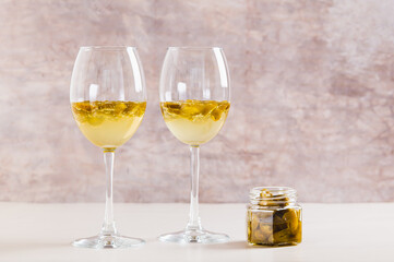 White wine infused with jalapeno slices in glasses on the table