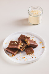 Chocolate nut protein bars on a plate on a table vertical view