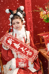 Charming young woman in traditional red attire holds a celebratory scroll, wishing prosperity and...