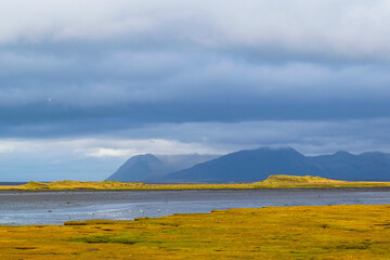 Scenic Icelandic coastal landscape with mountains and cloudy sky