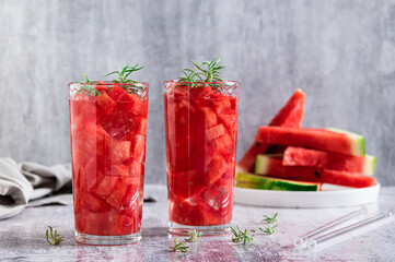 Detox summer drink with watermelon and rosemary in glasses on table