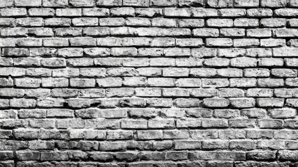 Fototapeta premium A close-up view of a weathered brick wall reveals the unique texture and character of the bricks, highlighting signs of age and time. The monochrome effect enhances its rustic appeal.