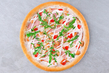 Chicken and Bacon Pizza with Arugula, Cherry Tomatoes, and Creamy Sauce on Gray Background