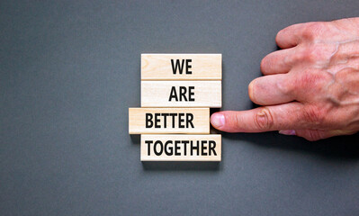 We are better together symbol. Concept words phrase We are better together on beautiful wooden blocks. Beautiful grey background. Businessman hand. Business We are better together concept. Copy space.