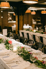 Elegant dining setup with floral decorations in a warm-lit restaurant for a special event