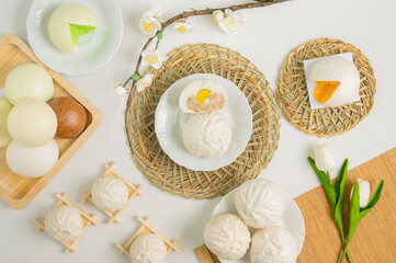 An overhead view of various steamed buns presented on woven mats, showcasing a delightful assortment of flavors and textures.
