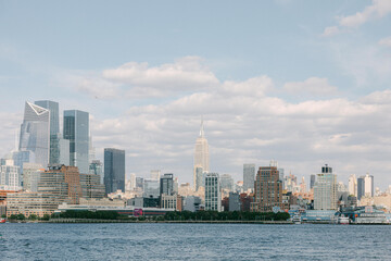 Fototapeta premium View of New York City skyline featuring modern buildings and the iconic Empire State Building on a clear day