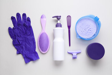 Hair care product for blonde hair and hairdresser's tools on white background, flat lay