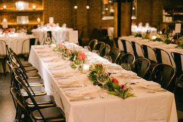 Elegant dining setup with white tablecloths and floral centerpieces in a cozy restaurant setting