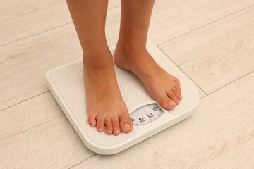 Little boy standing on scales indoors, closeup