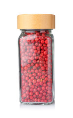 Red peppercorns in glass jar isolated on white. Aromatic spice