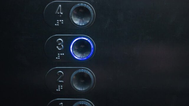 Close up of female hand with bright red nail polish pressing number three button on metallic elevator panel, highlighting modern transport, tactile detail, stylish gesture, and everyday urban
