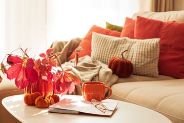 Cozy Autumn Living Room Scene with Mug, Notebook and Seasonal Decor under Sun Light