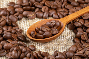 Artistic close-up of coffee beans in a wooden spoon on rustic table
