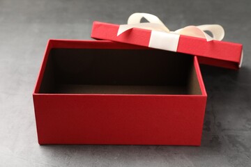 Opened gift box with beautiful lid on grey table, closeup