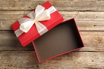 Opened gift box with beautiful lid on wooden table, top view